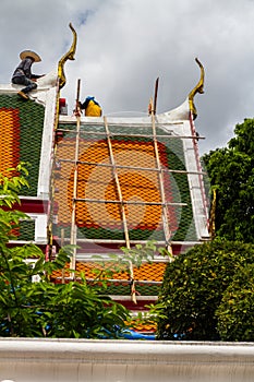 Editorial Workers repairing roof with bamboo scaffolding, Wat P